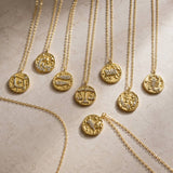 Collection of gold zodiac coin necklaces with crystal details, celestial jewellery trend for layering