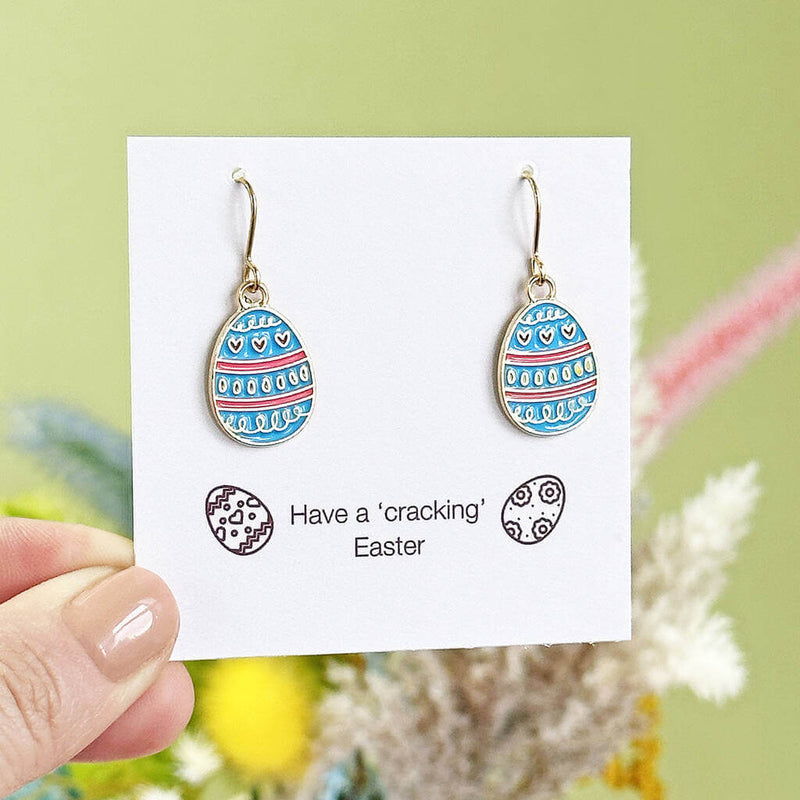 blue and pink stripe enamel Easter eggs charms on gold plated earring hooks displayed on a have a 'cracking' Easter sentiment card