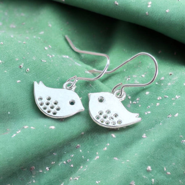 image shows a pair of silver love bird earrings on a green fabric background with silver flecks