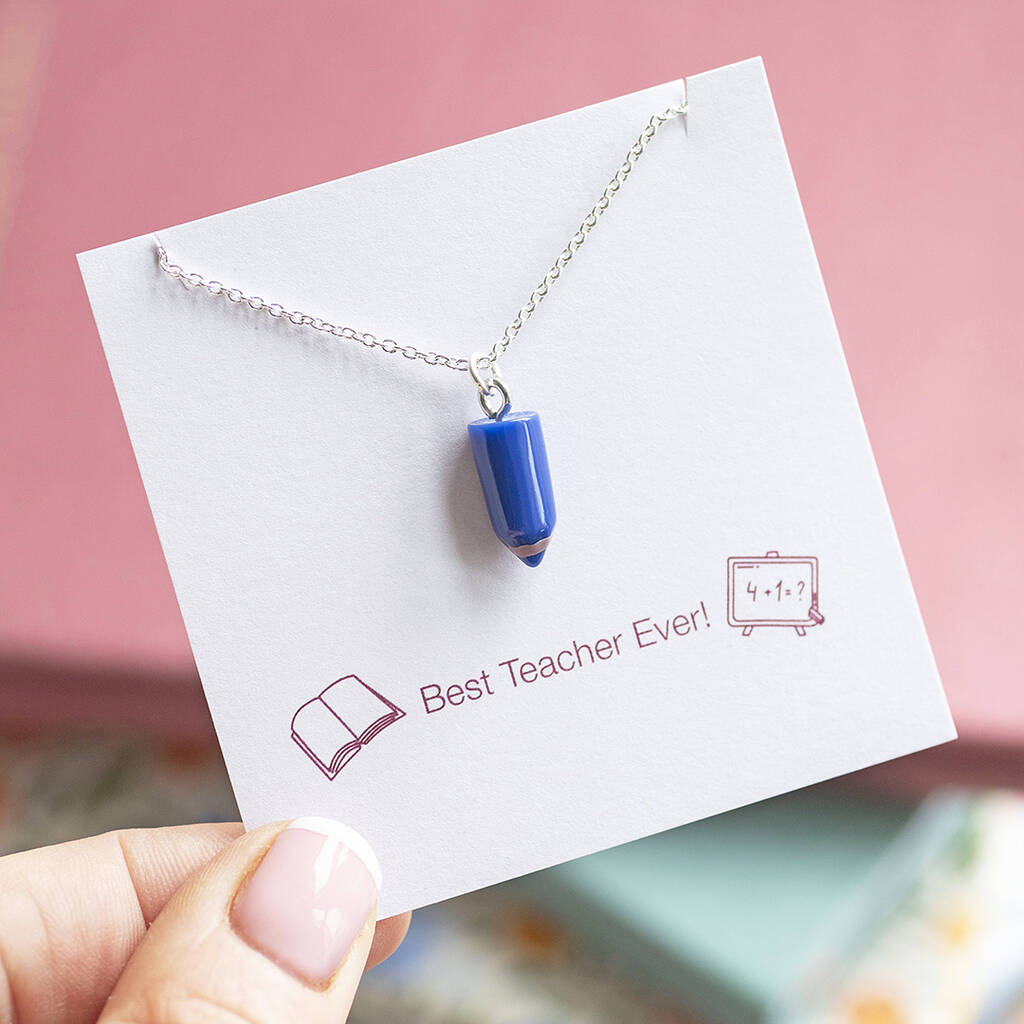 Blue pencil charm necklace with silver chain on a keepsake card, colourful statement jewellery with playful style.