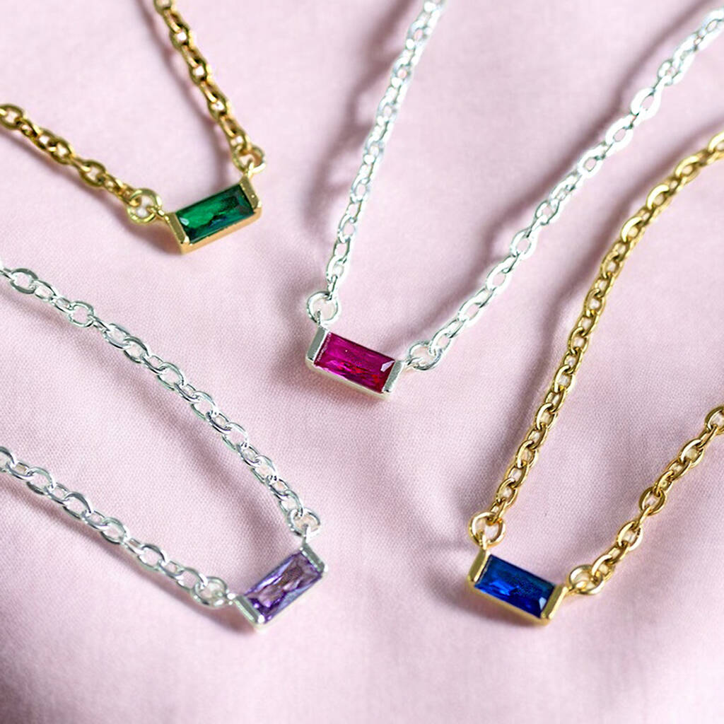 Colourful baguette birthstone necklaces in gold and silver tones, featuring green, pink, purple and blue stones.