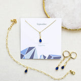 Image shows Dainty Teardrop Birthstone Jewellery Set in September Sapphire on a birthstone characteristics card.
