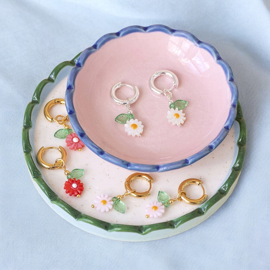 image shows scalloped trinket dishes with assorted handmade daisy hoop earrings