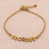 Gold plated vine bracelet with a pink birthstone crystal on a delicate chain, perfect for everyday styling