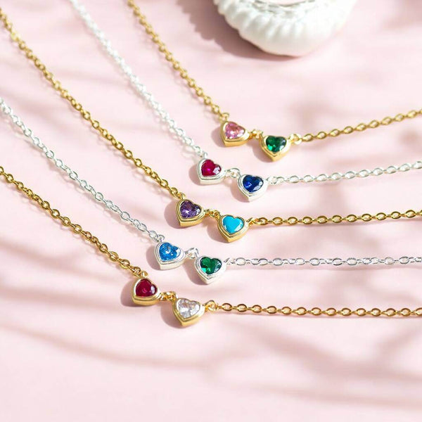 Double crystal heart charm link necklace shown in gold and silver with various birthstone combinations.