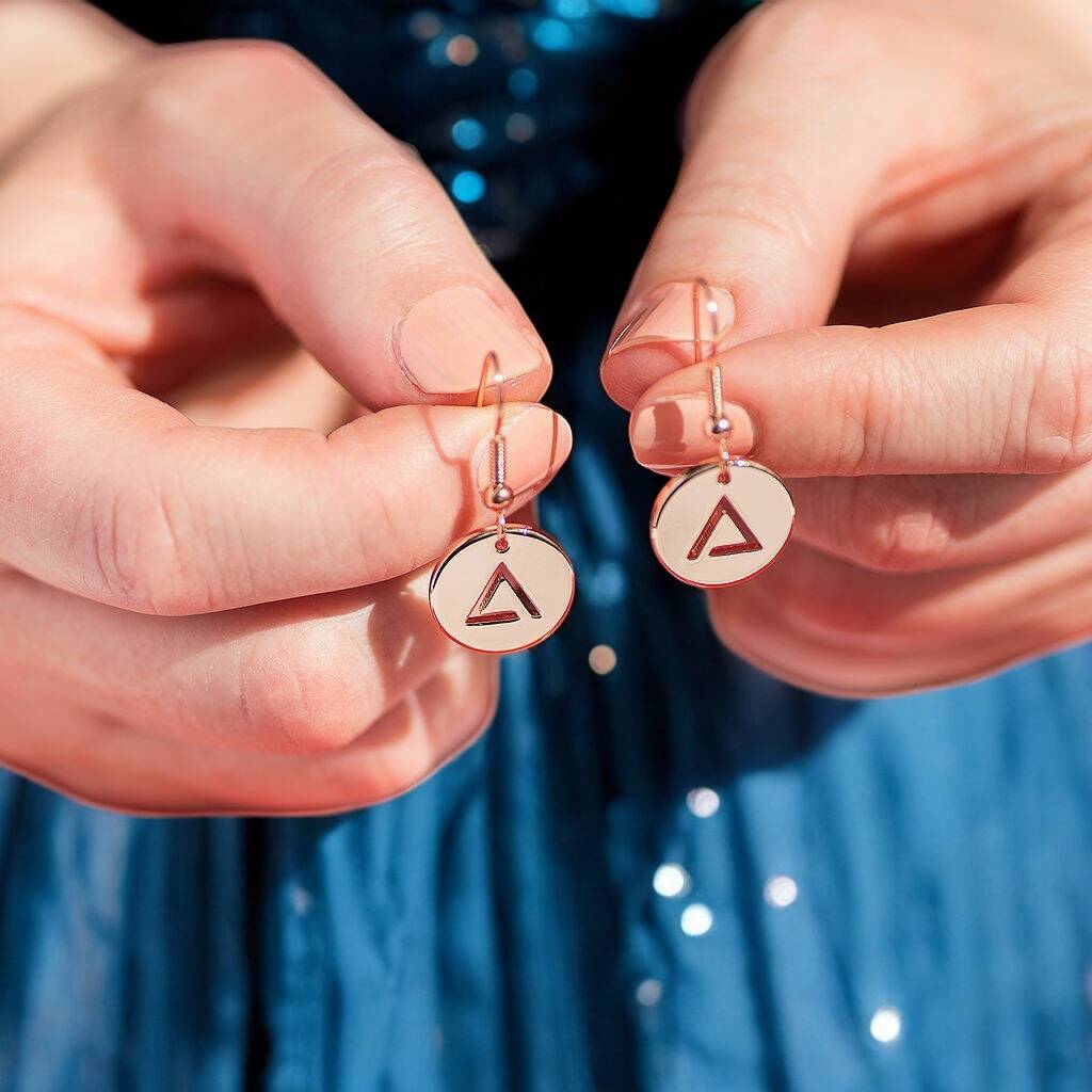 Image shows rose gold fire element earrings presented on a women's fingers