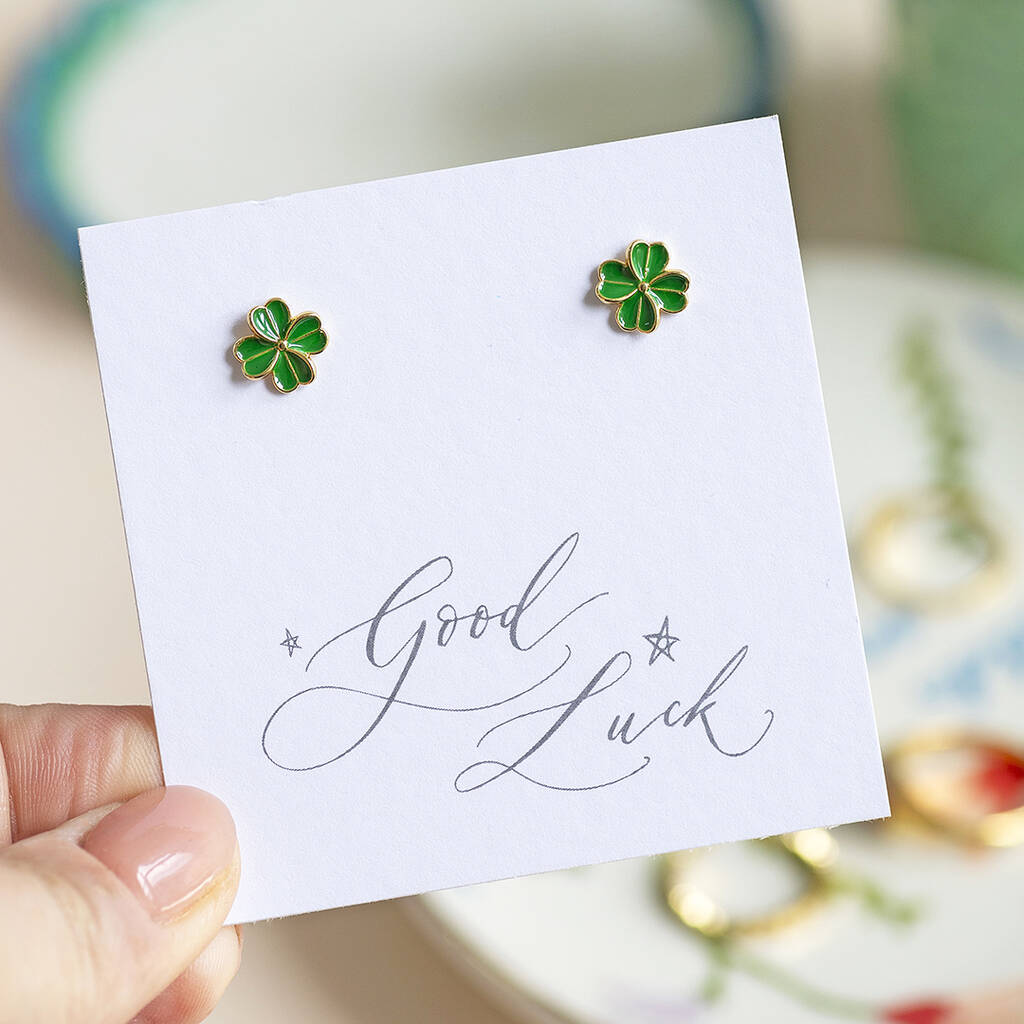 Gold plated green enamel four leaf clover stud earrings displayed on a Good Luck sentiment card.