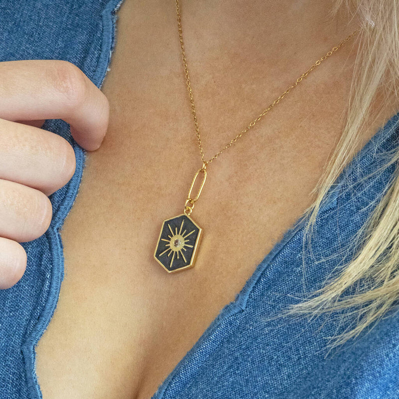 Image shows model in denim top wearing enamel hexagon star necklace in black