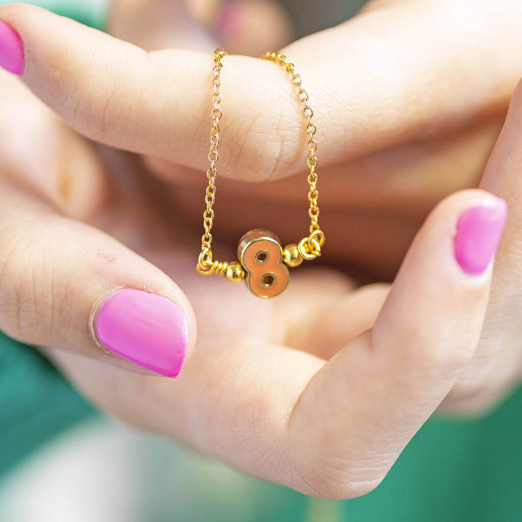 Model holds Enamel Number Necklace with the number "8".