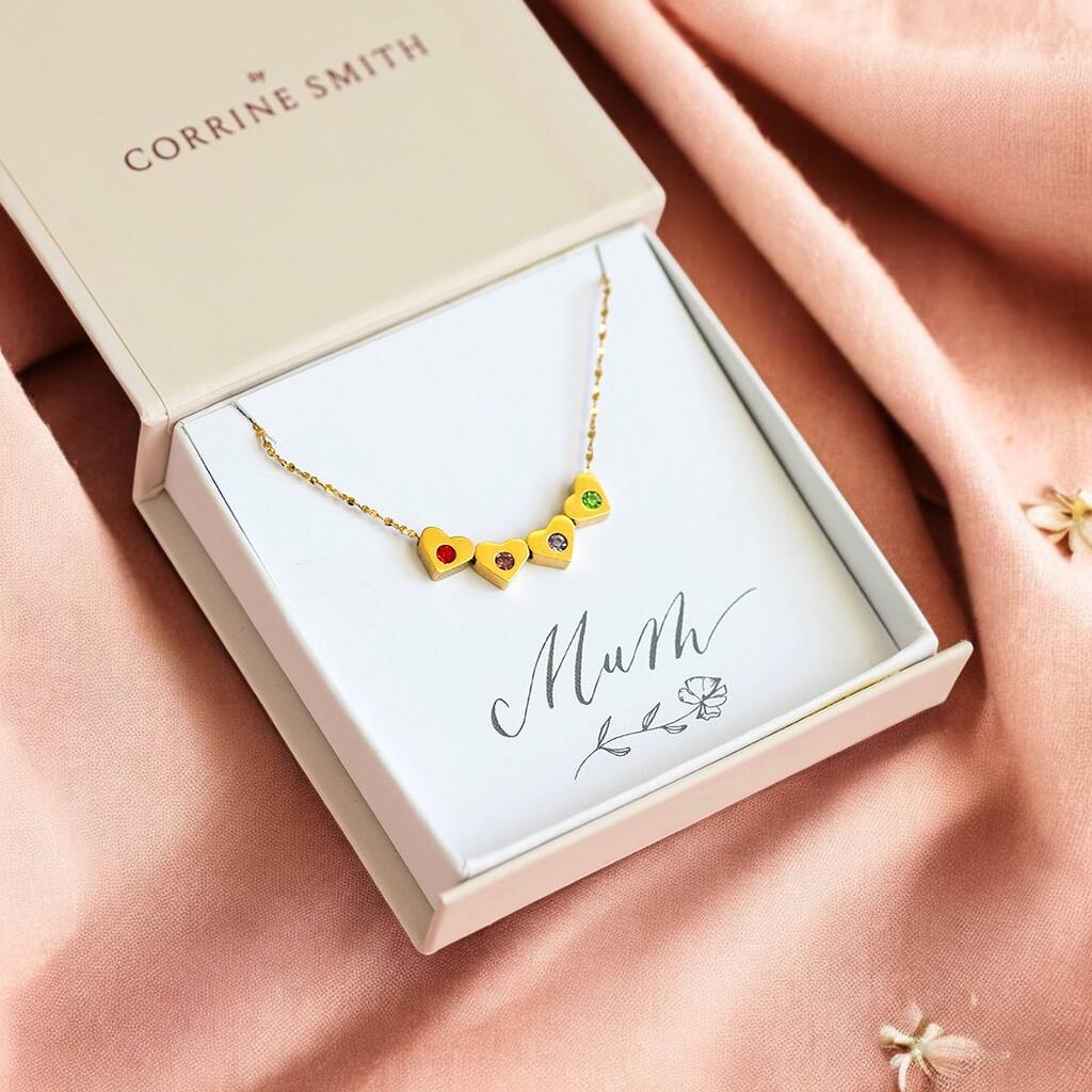 image shows a gift box with mum card containing a gold heart necklace set with family birthstines