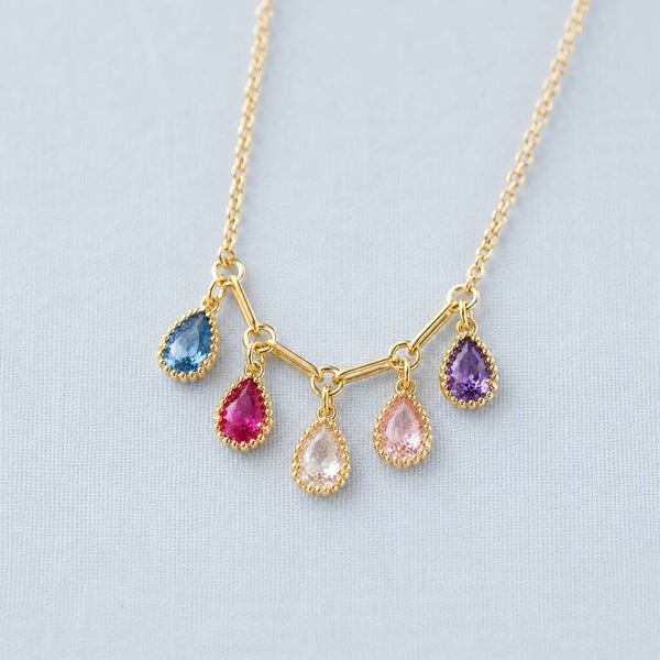 Close-up gold plated necklace with teardrop crystal drops in mixed colours, creating a delicate personalised look