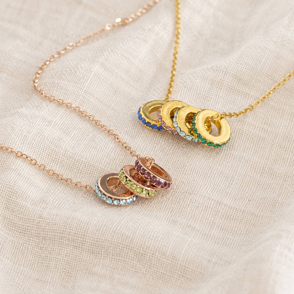 Colourful birthstone ring necklaces in gold and rose gold, featuring stacked crystal ring charms