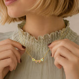 Gold heart birthstone necklace with colourful crystal details, styled as a delicate everyday layering piece