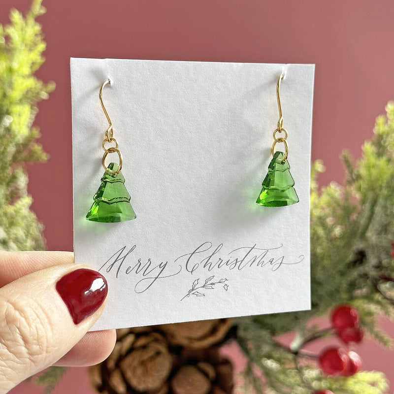 Image shows green glass christmas tree earring on a merry christmas sentiment card