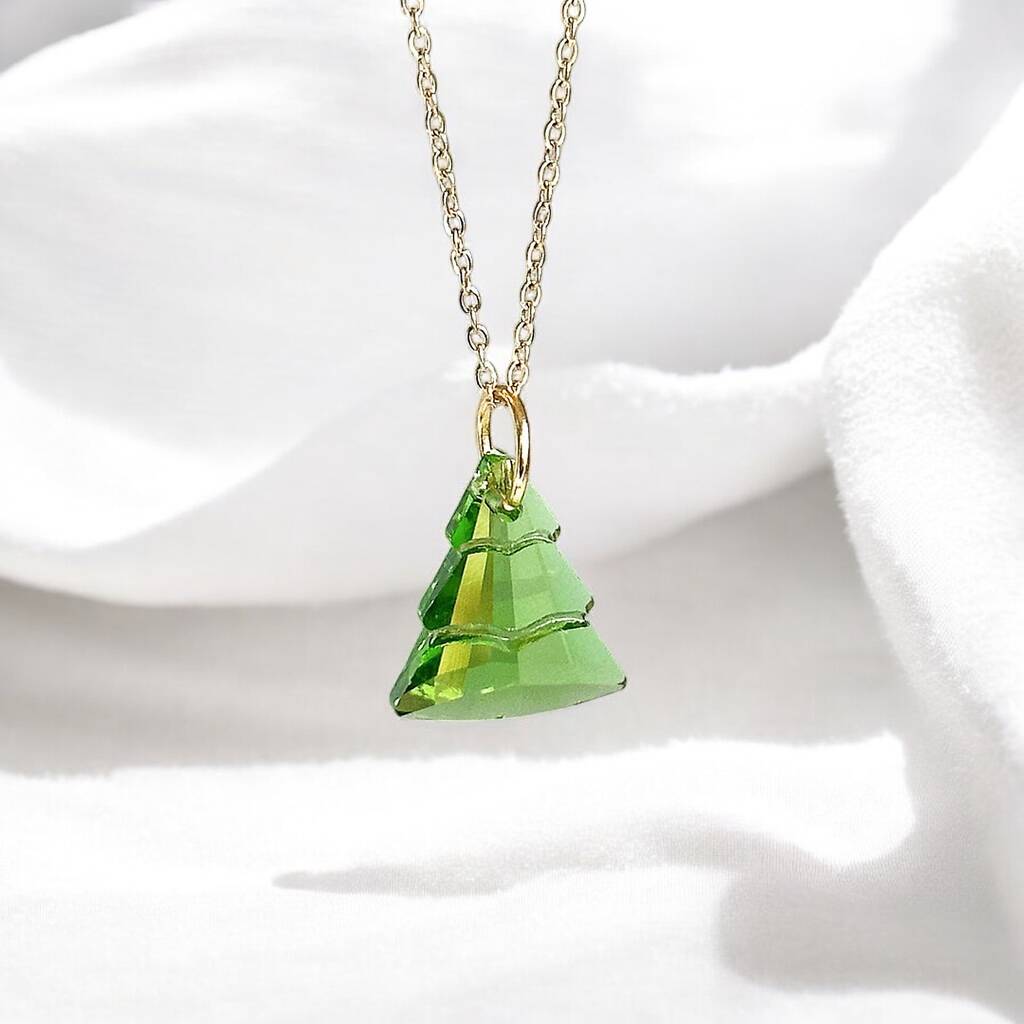 Image shows green glass Christmas tree charm suspended from a gold plated trace chain on a white background.