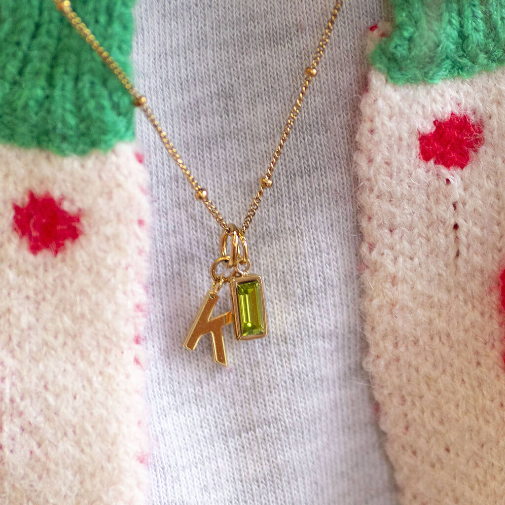 Model wearing gold initial necklace with baguette birthstone