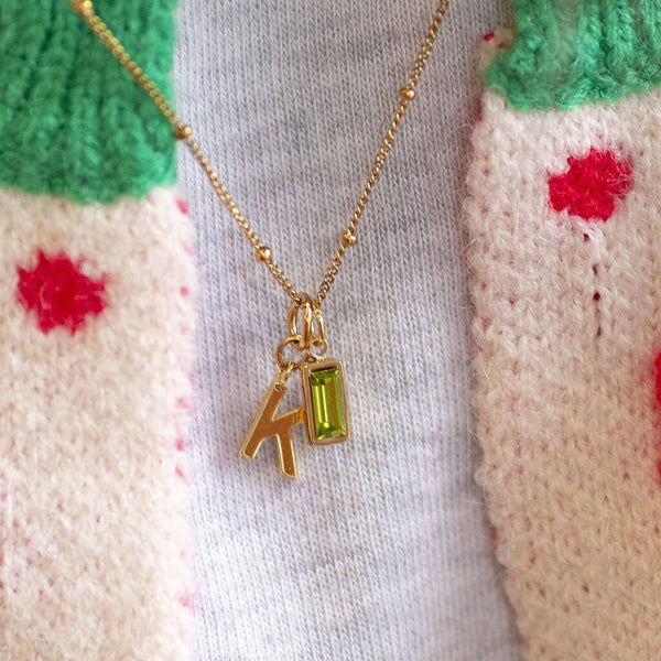 Model wearing gold initial necklace with baguette birthstone