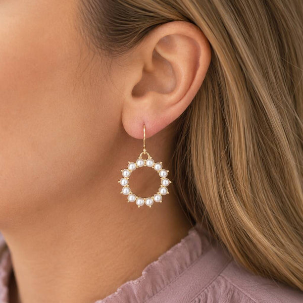 Statement pearl drop earrings with an open circular silhouette, creating an elegant feminine look