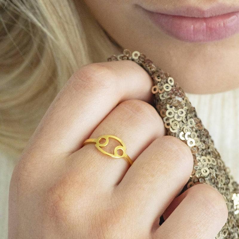 Images shows model wearing a gold plated adjustable zodiac ring