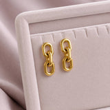 Polished gold chain link earrings with rounded open links, creating a bold yet refined statement accessory
