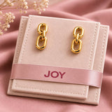 Gold chain drop earrings styled in a blush jewellery pouch, showcasing their sleek links and high-shine finish