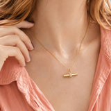 Polished gold plated T bar pendant with crystal embellishment, styled as a refined contemporary necklace look
