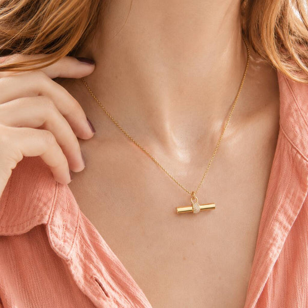 Polished gold plated T bar pendant with crystal embellishment, styled as a refined contemporary necklace look
