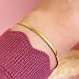 Model wears Gold Plated Flat Snake Chain Bracelet.