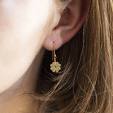 Gold plated four leaf clover earrings worn in the ear lobe