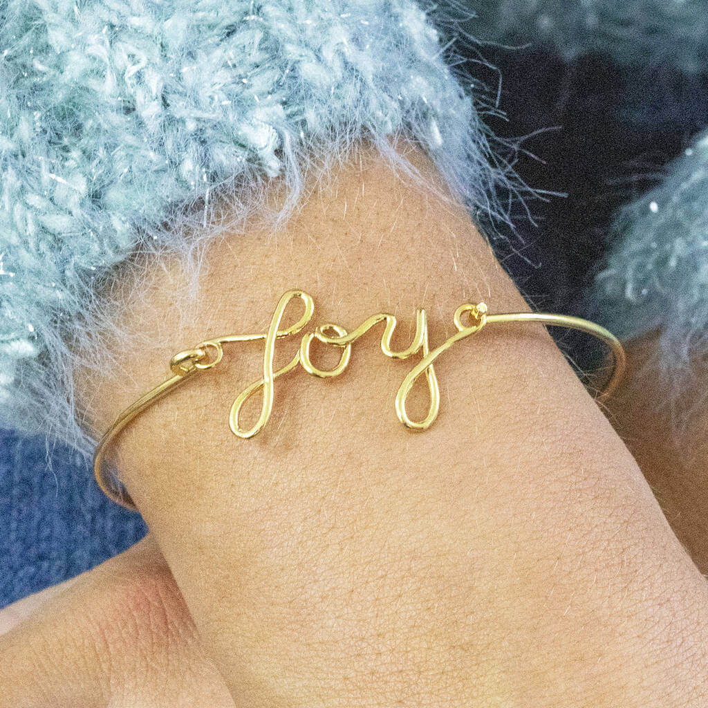 Model wears Gold Plated JOY Script Bracelet.