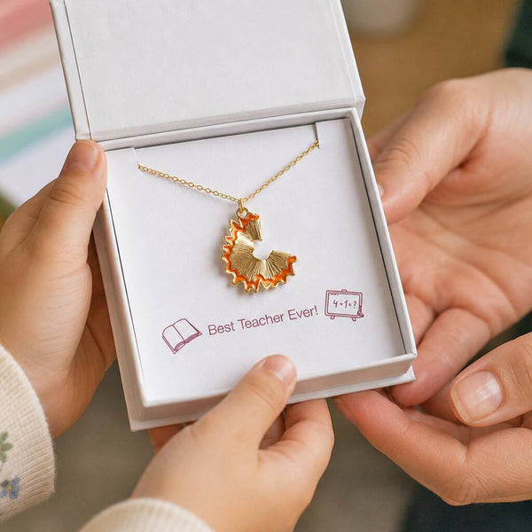 Gold pencil shaving pendant necklace displayed in gift box, creative jewellery inspired by classroom stationery