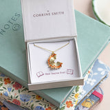 Gold pencil shaving pendant necklace presented in gift box on notebooks, stylish teacher-inspired jewellery gift