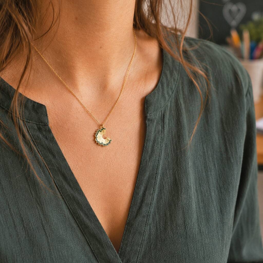 Gold pencil shaving pendant necklace styled with green blouse, quirky statement jewellery for everyday wear
