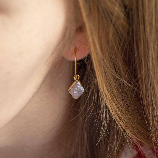 image shows model wearing rhombus shaped pearl hoop earrings