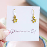 Gold plated cut out star drop earrings displayed on a Best Teacher Ever sentiment card