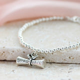 Detailed silver plated graduation scroll charm on a beaded stretch bracelet, perfect for stacking and everyday style