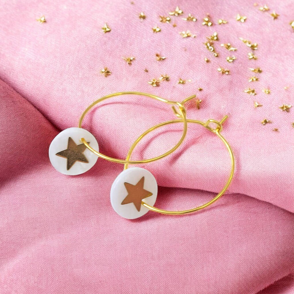 Image shows gold hoop earrings with a Mother of Pearl round disc featuring a gold star.