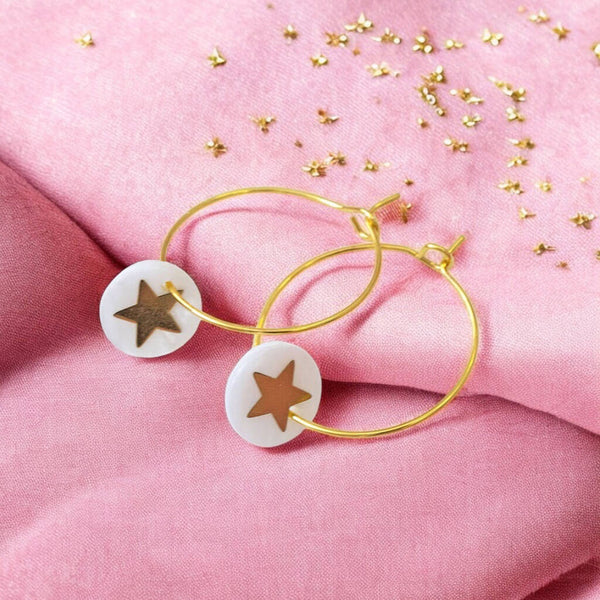 Image shows gold hoop earrings with a Mother of Pearl round disc featuring a gold star.