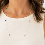 Long silver birthstone necklace styled with colourful crystal details, timeless jewellery for layering with everyday outfits.