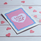 Romantic pink wall art print featuring Love Is All You Need quote in heart centrepiece