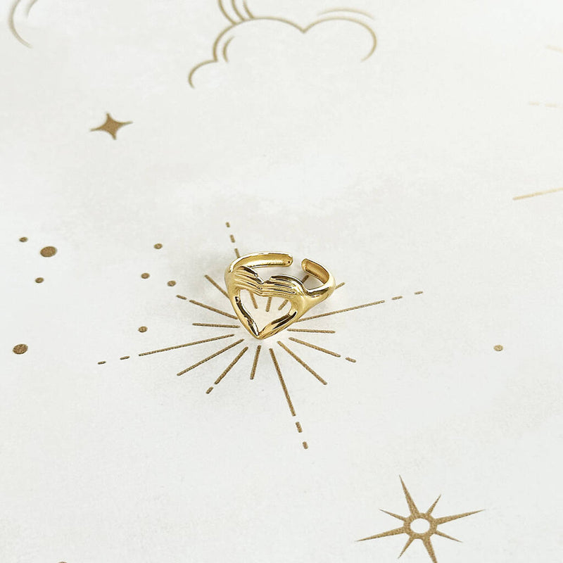 Image show love sign gold plated ring on a cream and gold starry background