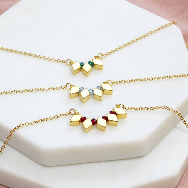 Image shows three Milestone Birthday Rhombus Birthstone Necklaces from top: May emerald birthstones, March Aquamarine and July Ruby.