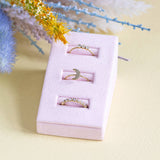 Image shows a crystal trio ring,  crystal moon ring and crystal band ring in a pink ring display..