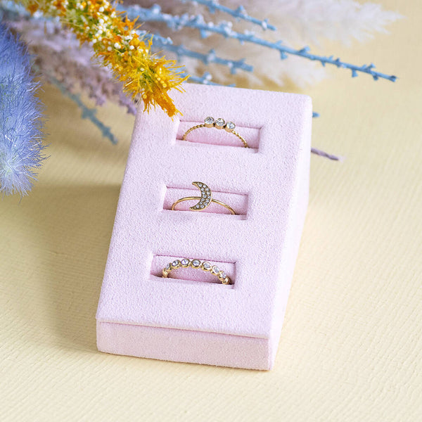 Image shows a crystal trio ring,  crystal moon ring and crystal band ring in a pink ring display..