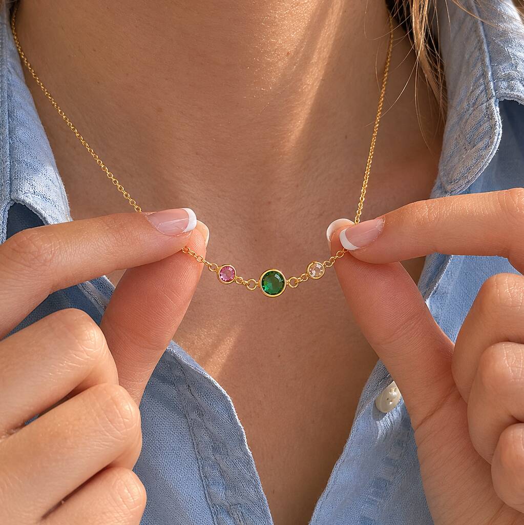 Gold birthstone link necklace with emerald centre stone and two smaller crystals, styled for everyday layering