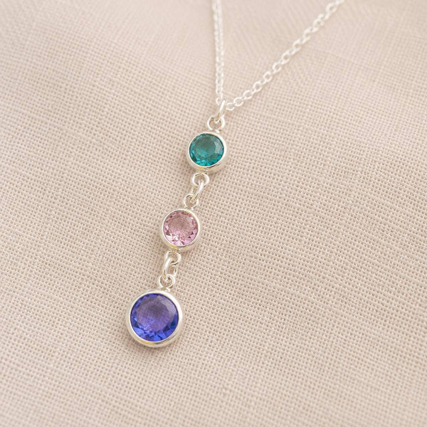 Silver birthstone pendant necklace featuring teal, blush pink and blue crystal drop charms