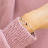 Silver plated circle birthstone bracelet layered on the wrist with two colourful crystals for a meaningful everyday look