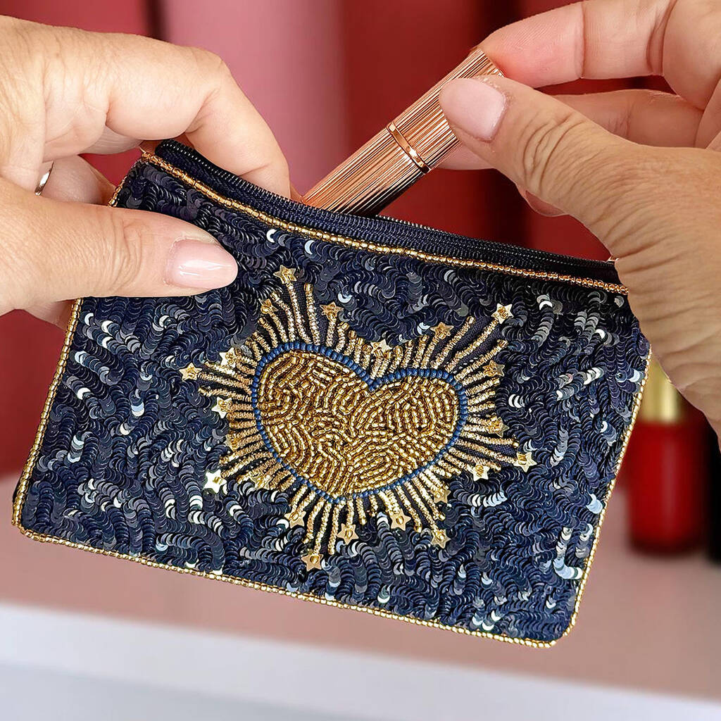 Close-up of navy pouch showing intricate gold beadwork in heart shape.