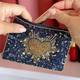 Close-up of navy pouch showing intricate gold beadwork in heart shape.