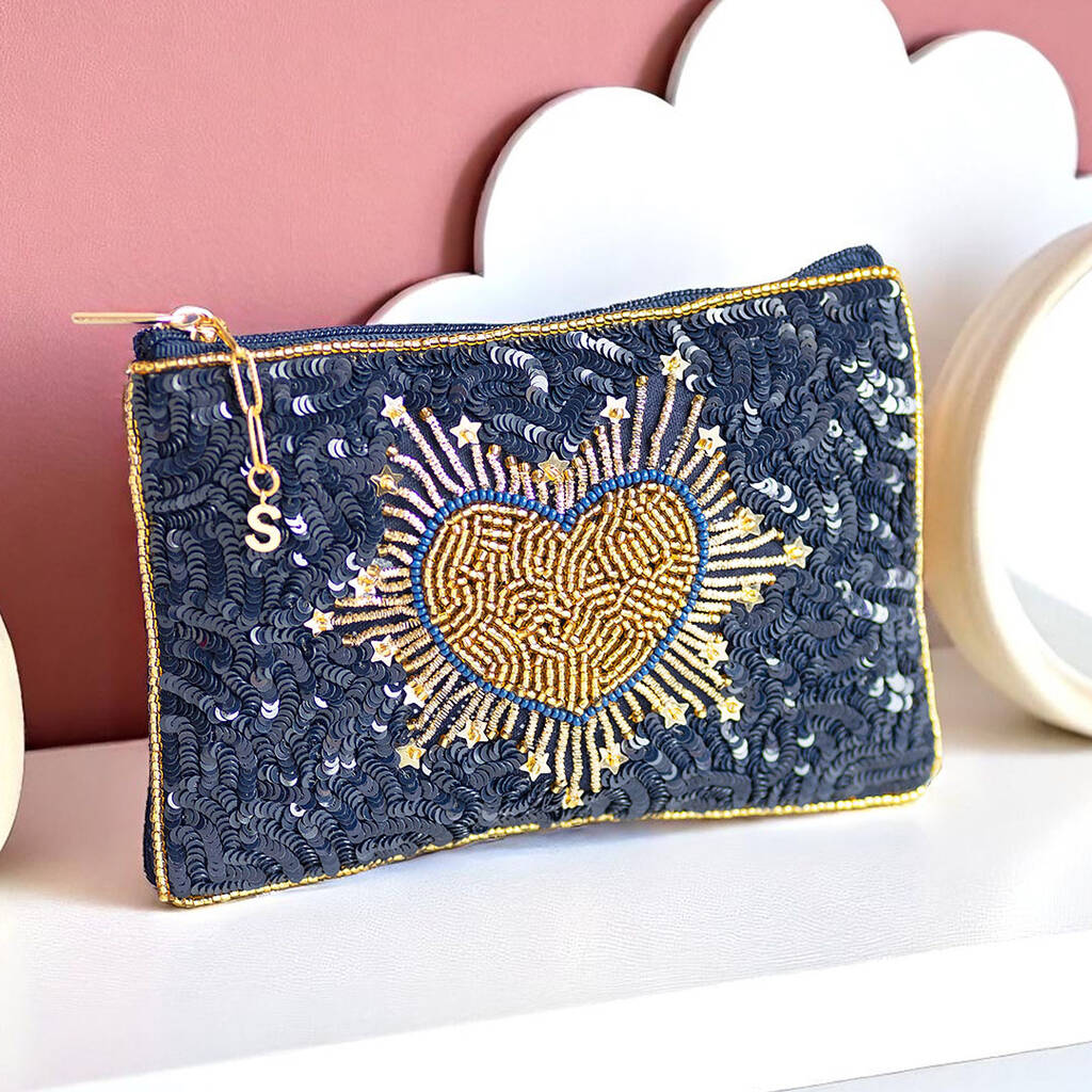Navy fabric pouch decorated with a hand-beaded gold heart, personalised with a gold initial charm on the zip.